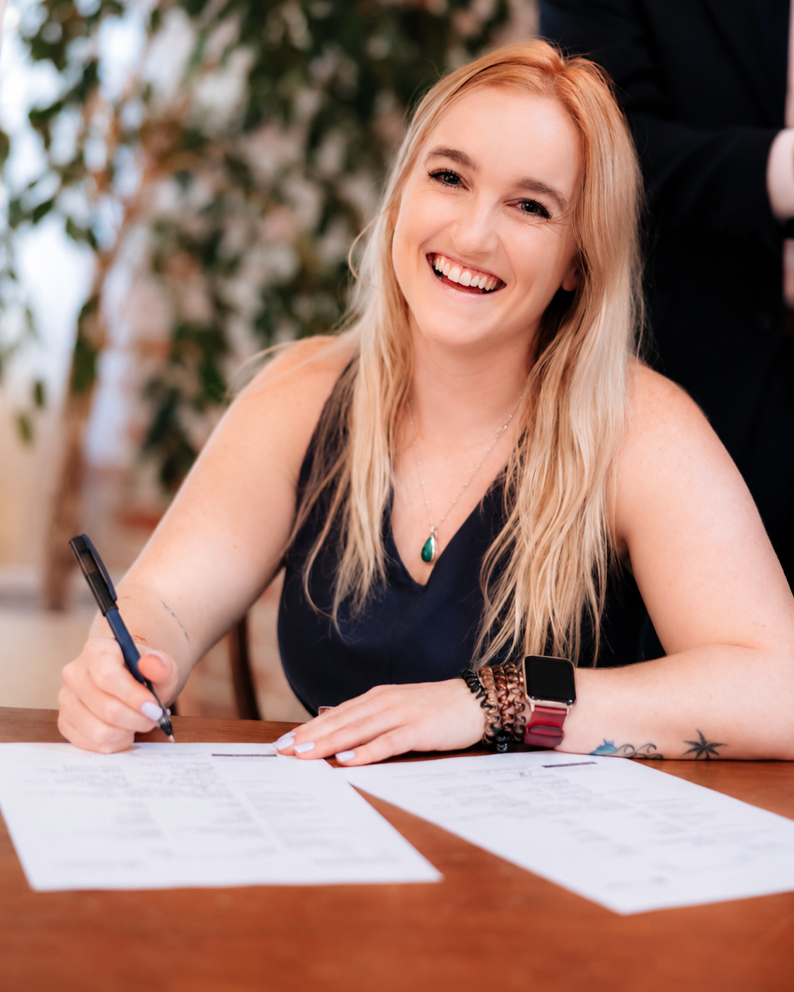 Johanna smiling while signing paperwork